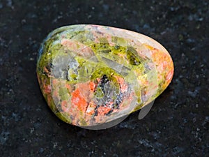 polished Unakite gemstone on dark background