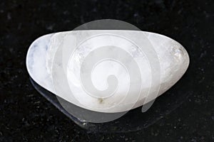 polished white moonstone (adularia) gem on dark