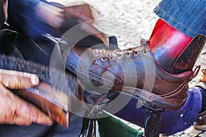 Polishing brown leather shoes with polishing grease