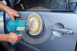 Polishing the car with power buffer machine photo