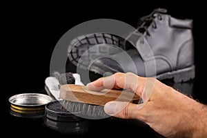 Polishing and cleaning leather shoes with a brush. Cleaning work shoes.