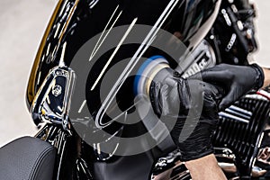 Polishing varnish on fuel tank in black motorcycle