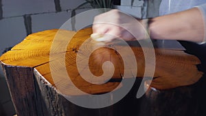 polishing a wooden stump with wood impregnation and shellac. cutting a wooden stump. woodworking concept. wood texture