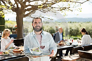 Bearded waiter welcoming on terrace