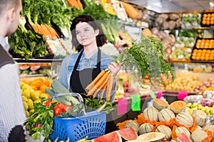 polite female seller assisting customer to buy fruit and vegetables in grocery shop