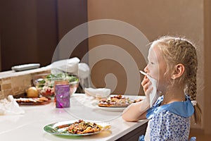 Polite little girl eating homemade pizza photo