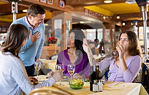 Polite man getting acquainted with women during lunch in restaurant