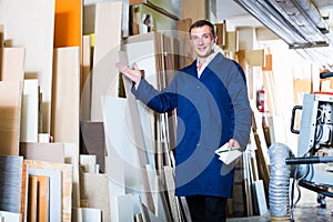 Polite workman standing with plywood pieces