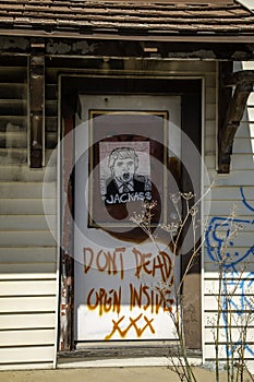 Political commentary graffiti on a door of an abandoned building