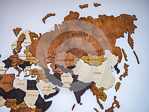 political map of the world made of wooden colored puzzle on a light wall