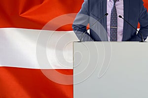 Political personality standing on the stage for conference on Austria flag background. Male speaker in Austria