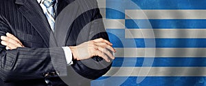 Politician crossed arms of on Greek flag background