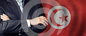 Politician crossed arms of on Tunisia flag background