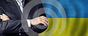 Politician crossed arms of on Ukraine flag background