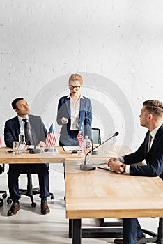 Politicians looking at redhead female colleague