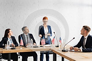 Politicians looking at smiling female colleague