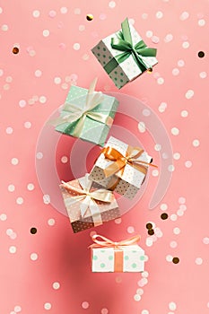 Polka dot pattern gift box with ribbon falling on pink background