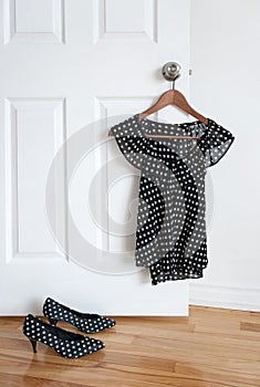 Polka dot shoes and stylish blouse on a hanger