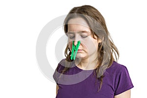 Pollen allergy concept. Young woman cant breathe and wearing peg on her nose