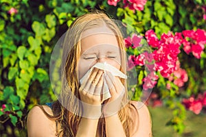 Pollen allergy concept. Young woman is going to sneeze. Flowering trees in background