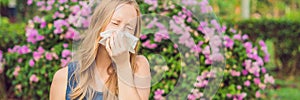 Pollen allergy concept. Young woman is going to sneeze. Flowering trees in background BANNER, long format