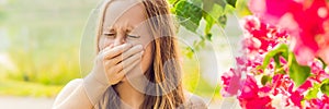 Pollen allergy concept. Young woman is going to sneeze. Flowering trees in background BANNER, long format