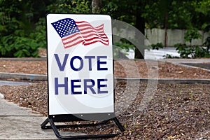 Polling place sign encouraging citizens to vote here at the local school. photo