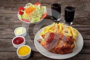 Peruvian food called Pollo a la brasa with salad and french fries photo