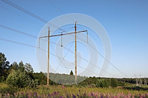 Polls of high-voltage power line on background of blue sky in rural areas