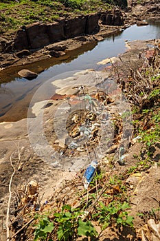 Polluted Garbage and Trash in a River Bank