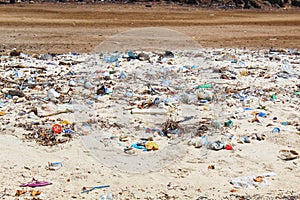 Polluted Sand Beach and Sea Area with Many Plastic Garbage or Trash Trown by the Locals