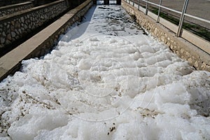 Pollution of a channel caused by surfactants. White foam in a stream kills life