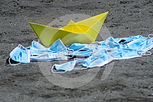 Pollution from masks with a paper boat concept art. Sea of masks.