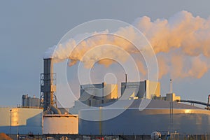 Pollution and smoke from the plant chimneys. View at sunset