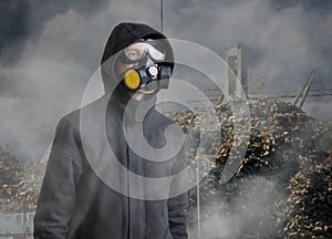 Pollution and toxic waste concept. Man with gas mask in front of landfill