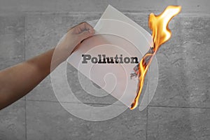 Pollution word text burning with fire on paper
