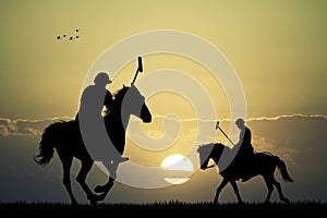 Polo players at sunset