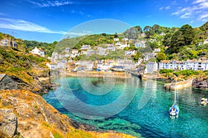Polperro Cornwall England uk with clear blue and turquoise sea in vivid colour HDR like painting photo