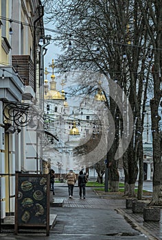 Rainy spring morning in the old town. People walking through the historic center in Poltava, Ukraine