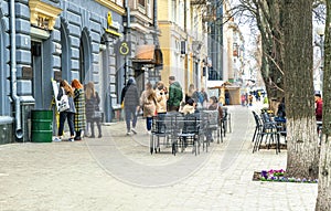 Rainy spring morning in the old town. People walking through the historic center in Poltava, Ukraine