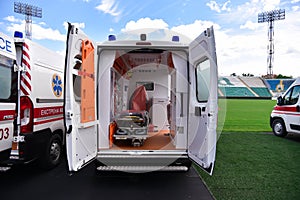 Ambulances stand at the stadium during the day