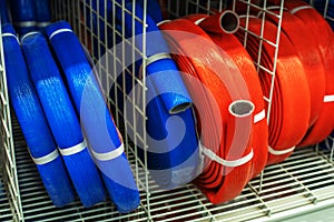 Polyethylene foam insulation for small diameter pipes. Rolls of blue and red material are on the counter in a specialist store.