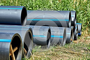 Polyethylene pressure pipes for water supply pipes with wooden struts to preserve the diameter lie on the grass