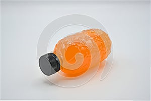 Polyethylene terephthalate plastic bottles and black lid with fresh orange juice