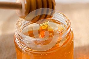 Polyfloral honey flows from a wooden honey spoon