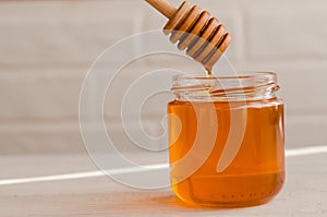 Polyfloral honey flows from a wooden honey spoon