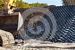 Polymer geogrid for filled with soil. Strengthening of sandy slopes with a geogrid