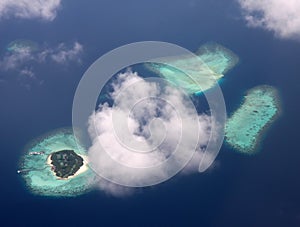 Polynesia. The atoll in ocean through clouds.