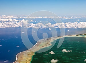 Polynesia. The atoll in ocean through clouds.