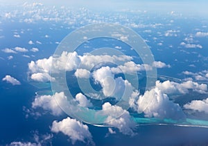 Polynesia. The atoll in ocean through clouds. Aerial view.